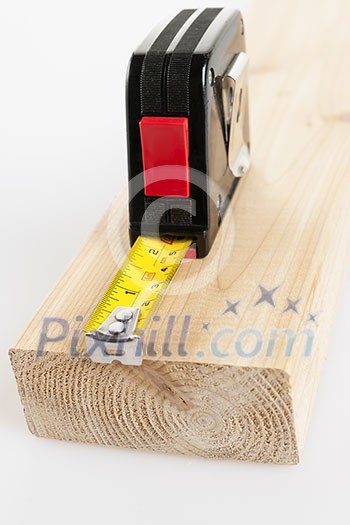 Metal imperial metric tape measure measuring two by four lumber Metal imperial metric tape measure measuring two by four lumber