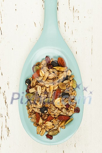 Homemade granola with various seeds and berries in wooden spoon shot from above Homemade granola with various seeds and berries in wooden spoon shot from above