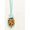 Homemade granola with various seeds and berries in wooden spoon shot from above