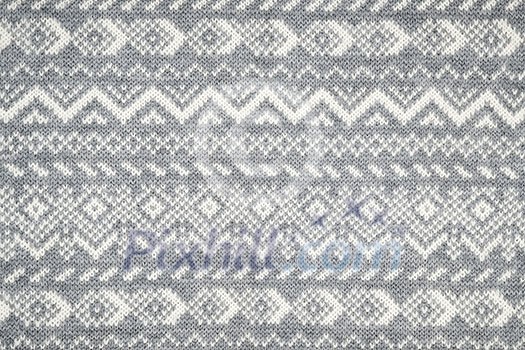 Knit fabric background with knitted grey and white geometric pattern Knit fabric background with knitted grey and white geometric pattern