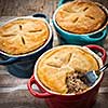 Closeup of three homemade gourmet meat pies with fork showing ground beef filling