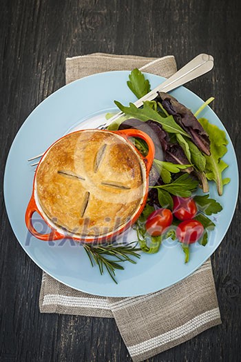 Gourmet meat pie with garden salad served on plate from above Gourmet meat pie with garden salad served on plate from above