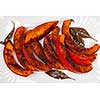 Roasted pumpkin slices served on white plate from above close up