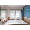 Home renovation of residential bathroom with large tub showing paint roller and sanding block