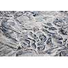 Grey and beige abstract background of wet sand texture formed by flowing water on beach