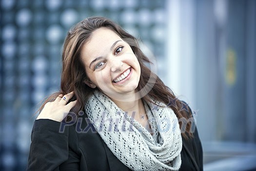 Candid portrait of young brunette woman smiling and touching her hair with copy space Candid portrait of young brunette woman smiling and touching her hair with copy space