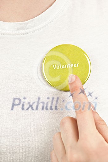 Closeup on female hand pointing to green volunteer button Closeup on female hand pointing to green volunteer button