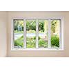Large four pane window looking on summer backyard with pool and garden