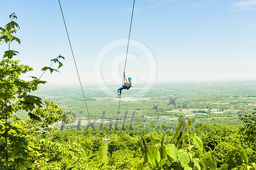 Young woman zip-lining with aerial countryside view at Blue Mountains, Ontario, Canada. Young woman zip-lining with aerial countryside view at Blue Mountains, Ontario, Canada.