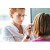 Optometry concept - pretty, young female optometrist examining her patient's eyes, finding the optimal correction to achieve optimal sight