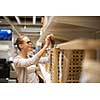 Pretty, young woman choosing the right furniture for her apartment in a modern home furnishings store (color toned image; shallow DOF)