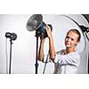Pretty, female photographer with digital camera - DSLR and a huge telephoto lens (color toned image; shallow DOF)