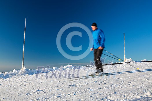 Cross-country skiing: young man cross-country skiing on a lovely sunny winter day (motion blur technique is used to convey movement) Cross-country skiing: young man cross-country skiing on a lovely sunny winter day (motion blur technique is used to convey movement)
