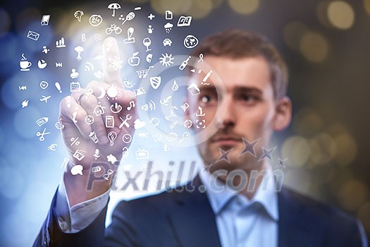 business man pressing touchscreen button with set of icons in air business man pressing touchscreen button with set of icons in air