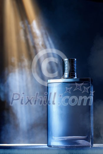 dramatic photo of perfume bottle with smoke and light rays dramatic photo of perfume bottle with smoke and light rays