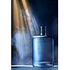 dramatic photo of perfume bottle with smoke and light rays