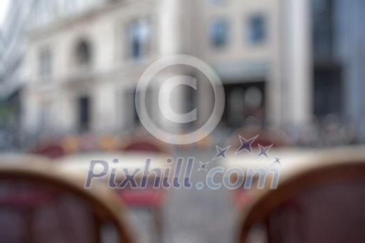 Background of blurred cafe on street of european city. Tables and chairs outside in natural bokeh Background of blurred cafe on street of european city. Tables and chairs outside in natural bokeh