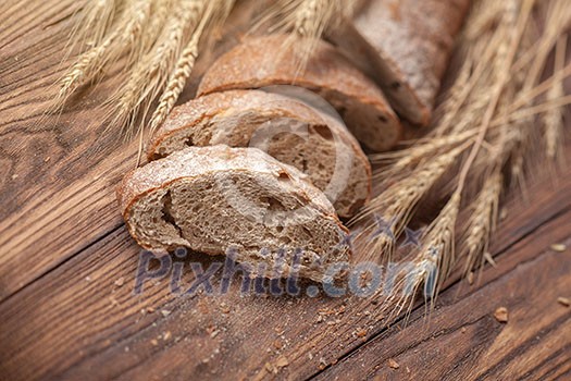 Bread and wheat on wooden table, shallow DOF, raw image Bread and wheat on wooden table, shallow DOF, raw image