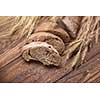 Bread and wheat on wooden table, shallow DOF, raw image
