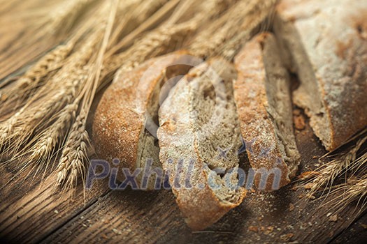 Bread and wheat on wooden table, shallow DOF, raw image Bread and wheat on wooden table, shallow DOF, raw image