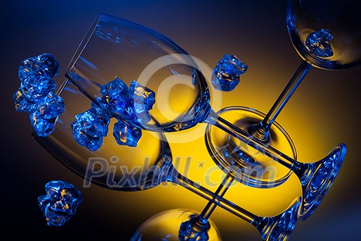 ice and empty wineglasses on color background ice and empty wineglasses on color background