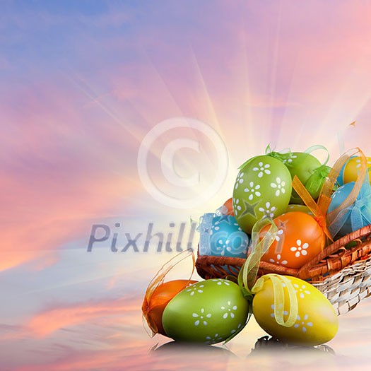 color easter eggs in basket against sky and clouds