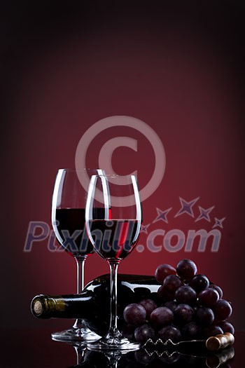 Wine in glasses with grape and bottle on red Wine in glasses with grape and bottle on red