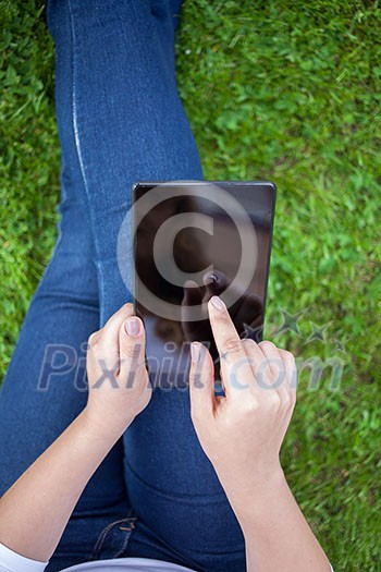 Woman using digital tablet PC in the park Woman using digital tablet PC in the park