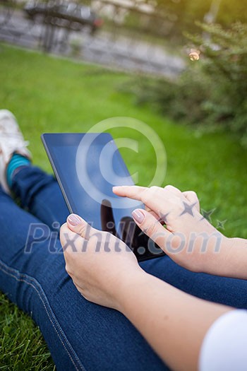 Woman using digital tablet PC in the park Woman using digital tablet PC in the park