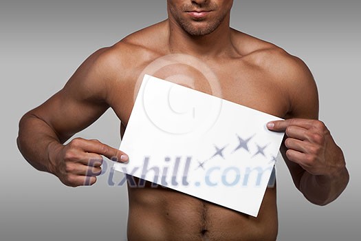 Muscular naked man holding white empty paper Muscular naked man holding white empty paper