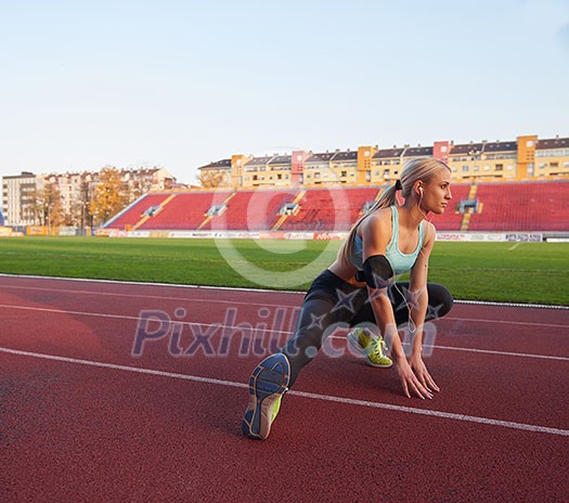 young runner sporty woman relaxing and stretching on athletic race track young runner sporty woman relaxing and stretching on athletic race track
