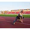 young runner sporty woman relaxing and stretching on athletic race track