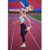 young runner sporty woman relaxing and stretching on athletic race track