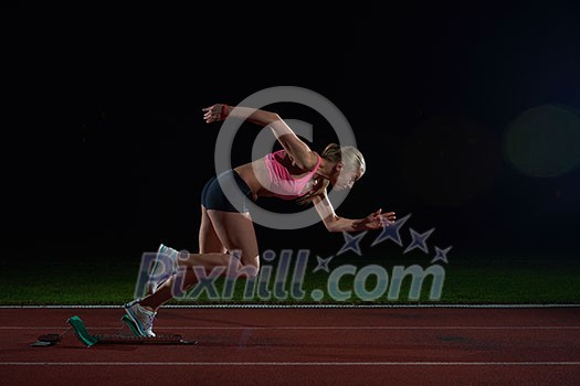 woman sprinter leaving starting blocks on the athletic track. Side view. exploding start woman sprinter leaving starting blocks on the athletic track. Side view. exploding start