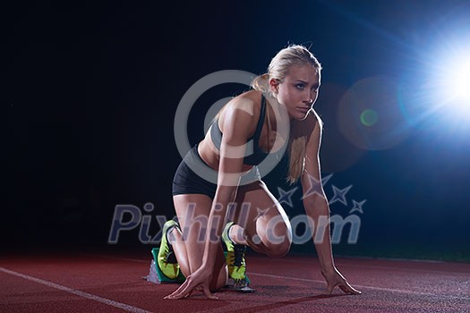 woman sprinter leaving starting blocks on the athletic track. Side view. exploding start woman sprinter leaving starting blocks on the athletic track. Side view. exploding start