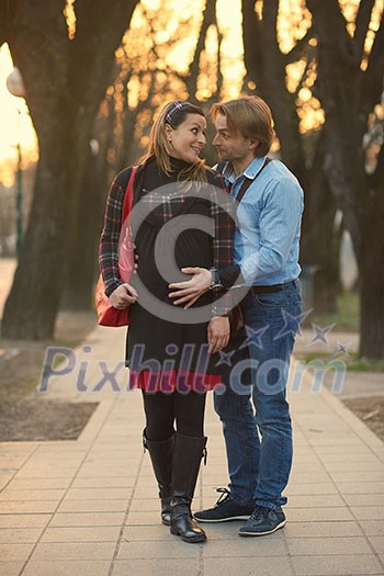 Happy and young pregnant couple have fun and relax outdoor Happy and young pregnant couple have fun and relax outdoor
