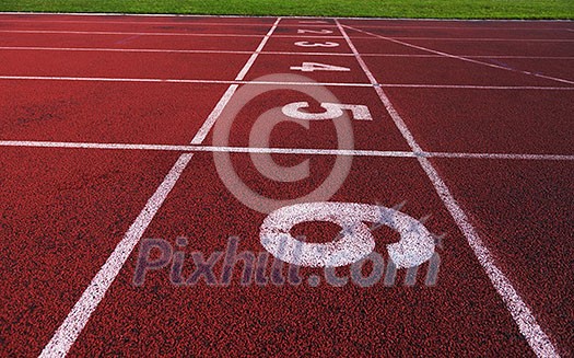 Red athletic track treadmill at the stadium with the numbering. Red athletic track treadmill at the stadium with the numbering.