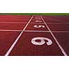 Red athletic track treadmill at the stadium with the numbering.