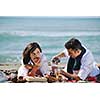 happy young couple enjoying  picnic on the beach and have good time on summer vacations
