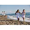 happy young family in white clothing have fun and play with beautiful dog at vacations on beautiful beach 