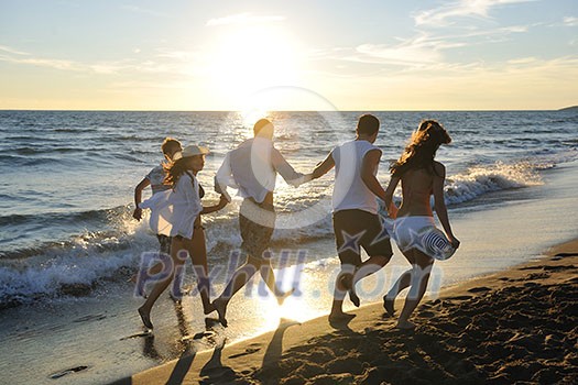 happy young people group have fun white running and jumping on beacz at sunset time happy young people group have fun white running and jumping on beacz at sunset time