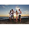 happy young friends group have fun and celebrate while jumping and running on the beach at the sunset