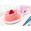 Closeup of pink raspberry mousse dessert with cherry blossom