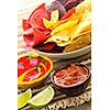 Bowl of salsa with colorful tortilla chips and lime