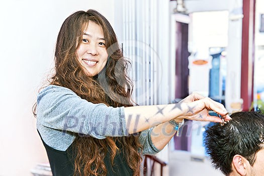 Happy hairstylist cutting hair in her salon Happy hairstylist cutting hair in her salon