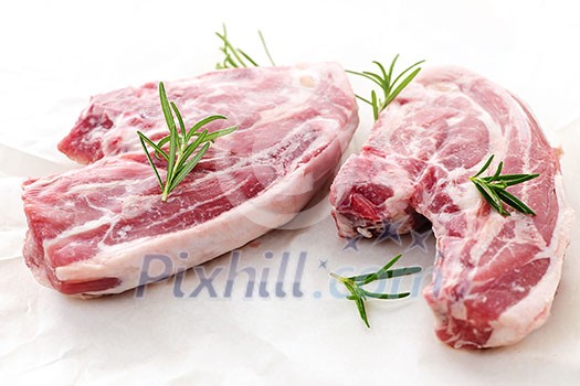 Two raw fresh lamb chops with rosemary herb Two raw fresh lamb chops with rosemary herb