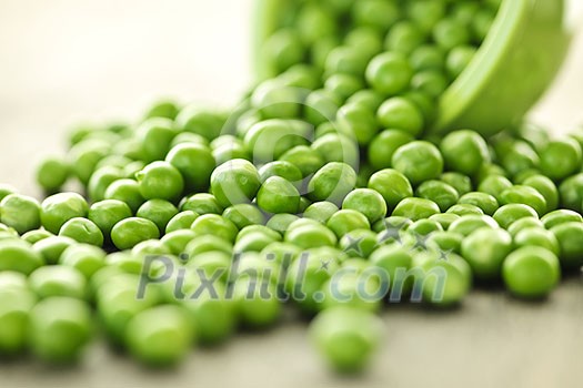 Closeup on spilling bowl of fresh green green peas Closeup on spilling bowl of fresh green green peas