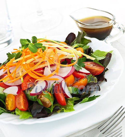 Plate of healthy green garden salad with fresh vegetables served with balsamic dressing Plate of healthy green garden salad with fresh vegetables served with balsamic dressing