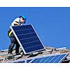 Man installing alternative energy photovoltaic solar panels on roof