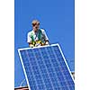 Man installing alternative energy photovoltaic solar panels on roof